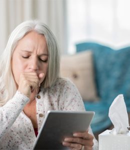 sick woman using her tablet to talk to a medical professional