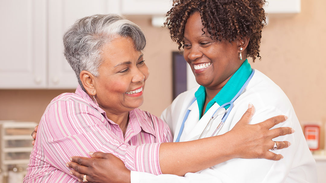 desktop-Doctor-gives-senior-adult-patient-hug-at-clinic-office-GettyImages-638590278