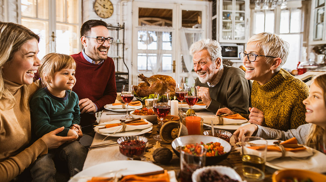 desktop-Happy-smiling-family-talking-Thanksgiving-Christmas-holiday-meal-dining-table-home-GettyImages-1163699224