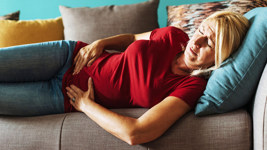 desktop_Mature-senior-middle-aged-woman-pelvic-pain-discomfort-laying-down-on-couch-at-home-GettyImages-836755882