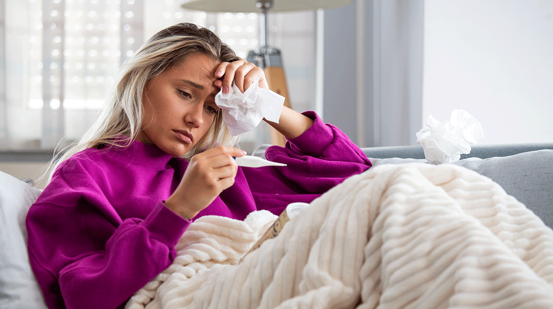 desktop_Woman-sick-seasonal-illness-virus-flu-cold-at-home-checking-high-fever_GettyImages-1175000095