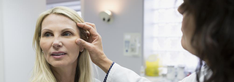 doctor-inspecting-womans-face