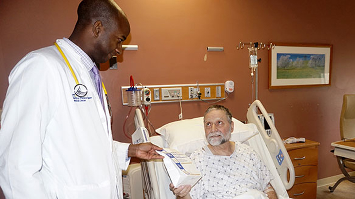 Doctor talking to patient in hospital bed