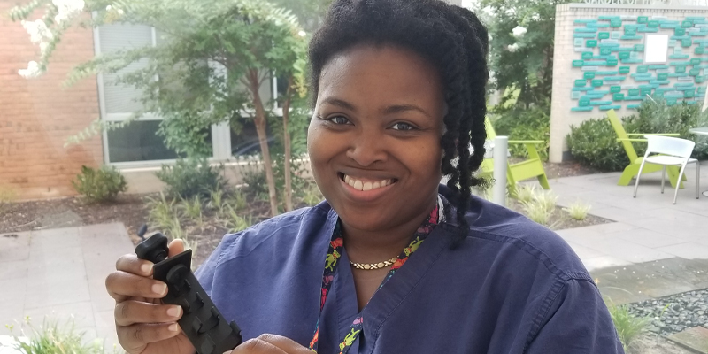 Tiffany Morris, RN, BSN, a MedStar Franklin Square Medical Center NICU nurse, holding her award-winning invention: MedStar Health’s gravity feed syringe holder.