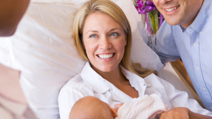 parents smiling with new born baby