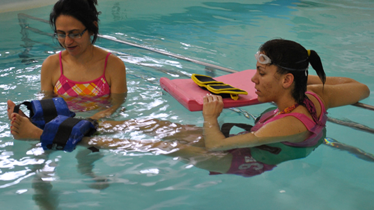 Physical therapist giving aquatic therapy to patient