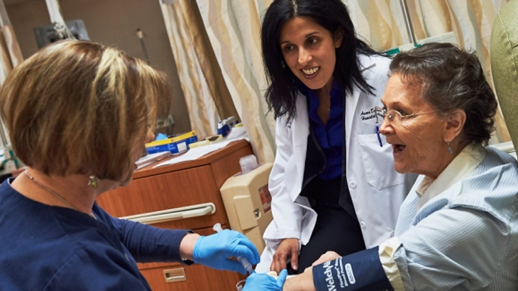 Image of a breast cancer patient with two health care professionals