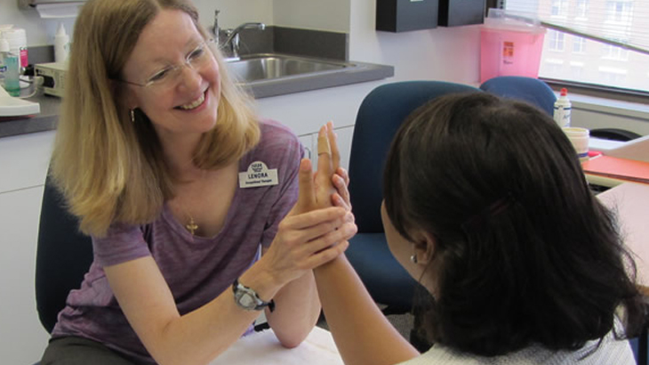 Image of a healthcare professional examining a patient's hand