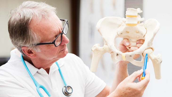 Doctor points out a hip joint on a model skeleton
