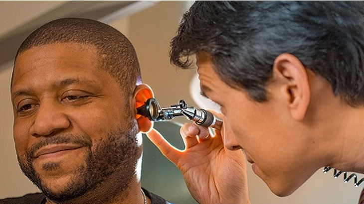 Otolaryngologists examining patient's ear