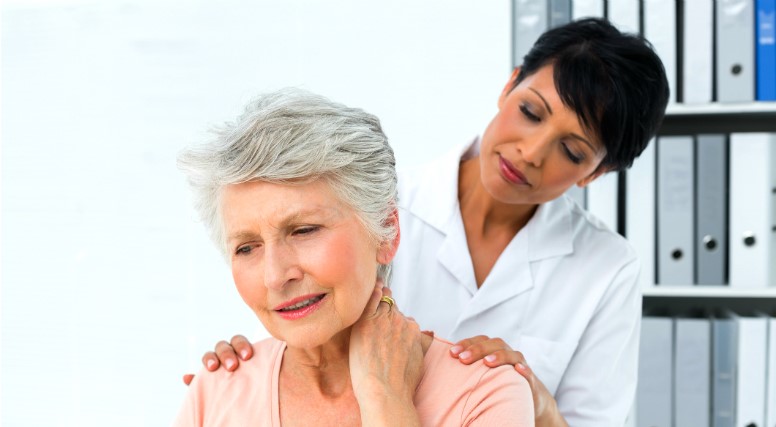 Health professional evaluates woman with neck pain