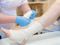 Wound care specialist applying bandage to wound