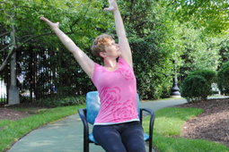 image of a woman in a park doing yoga from her chair