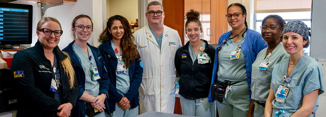 Dr. Katharine Harper holds a letter of gratitude while posing for a photo with orthopedics office staff.