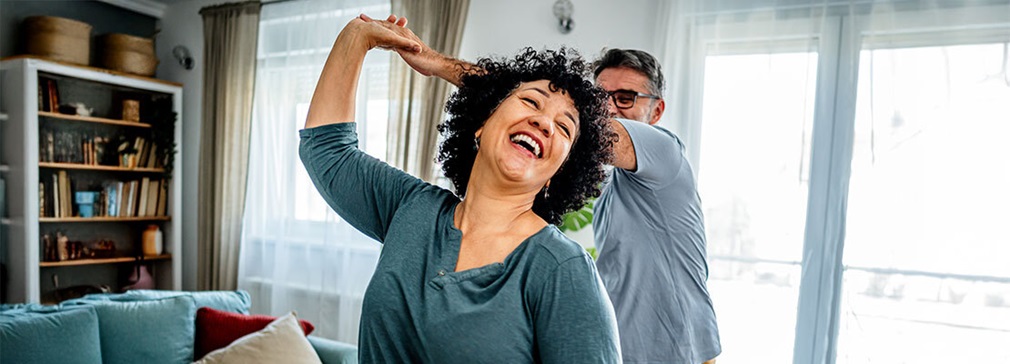 A man hits a golf ball on a golf course in a warm sunny location.