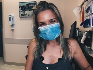 Brown haired woman wearing blue face mask